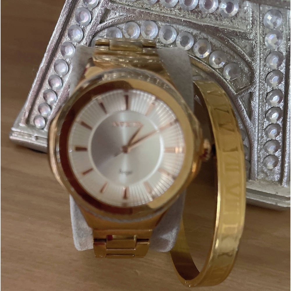 Women’s gold Invicta watch with gold bangle bracelet